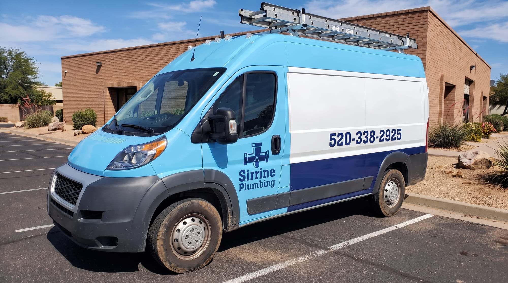 Sky-blue Sirrine Plumbing work van with the company logo on its front door and the phone number on the side, parked in front of a brick building
