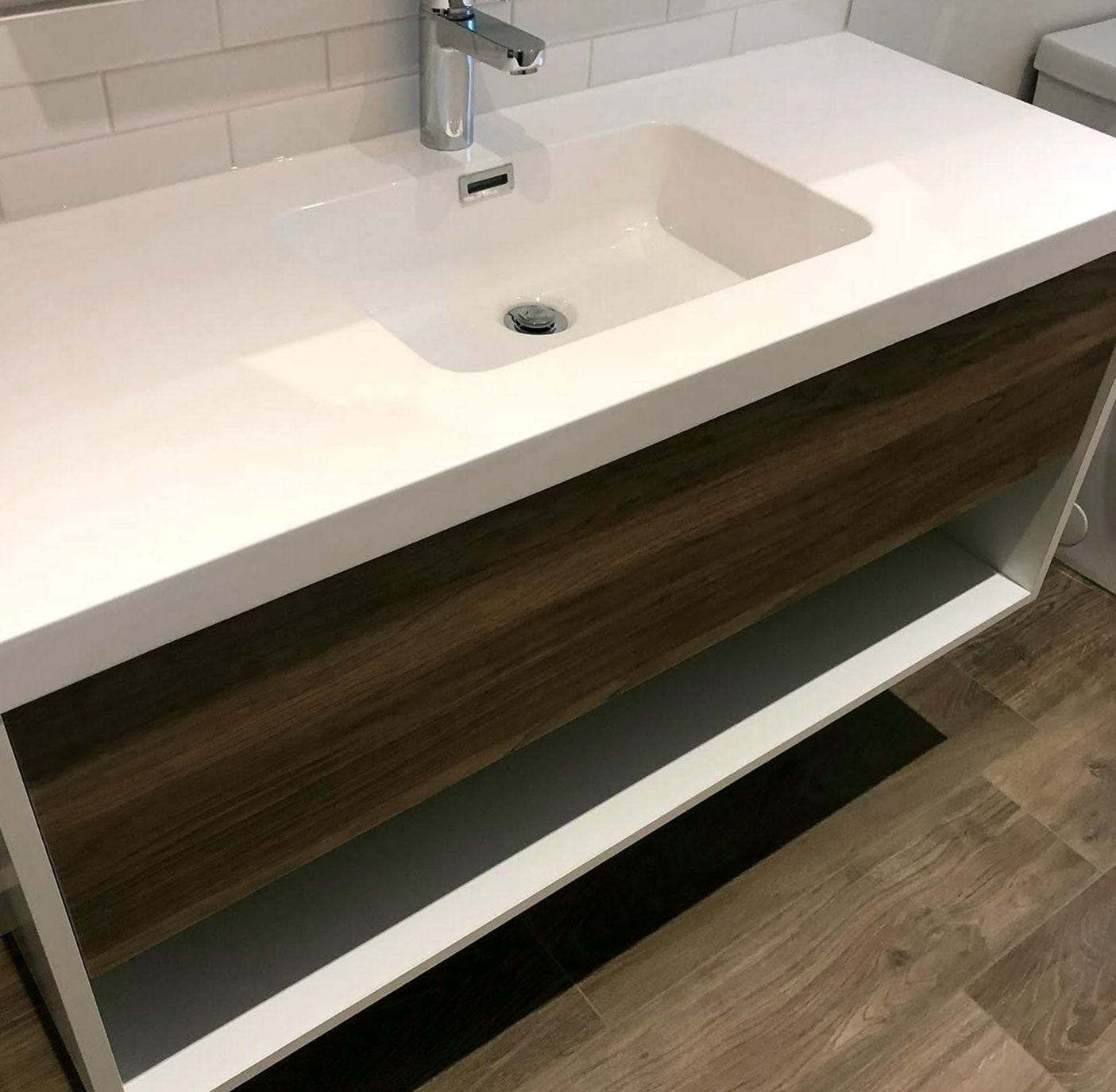 Floating vanity with a wide integrated white sink and a single-handle chrome faucet